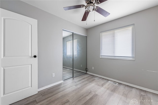 unfurnished bedroom featuring ceiling fan, light hardwood / wood-style flooring, and a closet