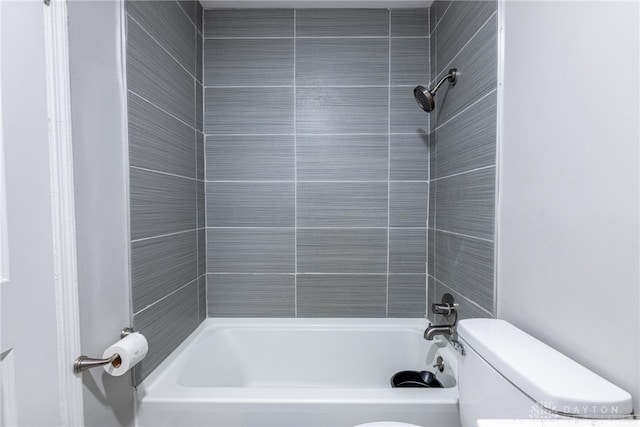 bathroom featuring tiled shower / bath combo and toilet