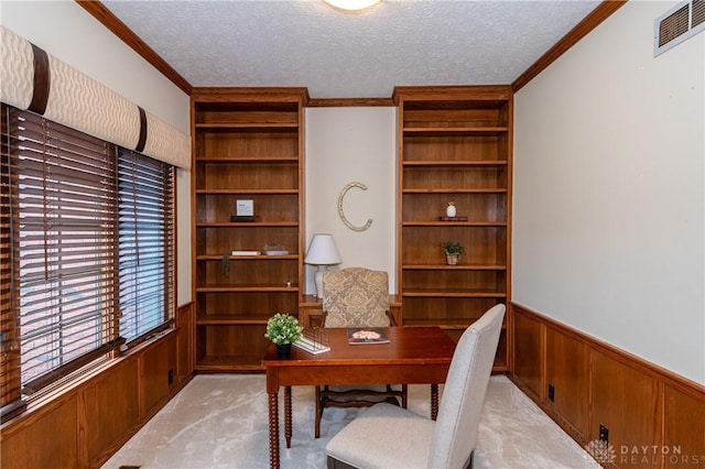 office area featuring light carpet, a textured ceiling, crown molding, and wooden walls