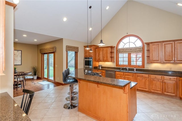 kitchen featuring a kitchen bar, sink, a kitchen island, and decorative light fixtures