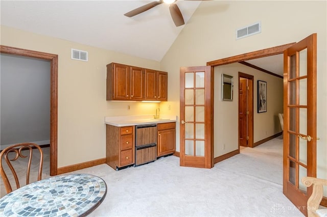 kitchen featuring french doors, light colored carpet, vaulted ceiling, and ceiling fan