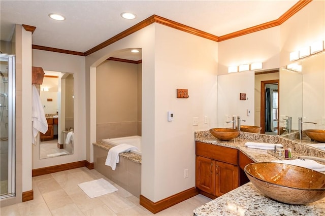 bathroom featuring tile patterned flooring, vanity, ornamental molding, and tiled tub