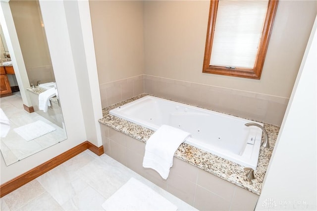 bathroom with tiled tub, tile patterned flooring, and vanity