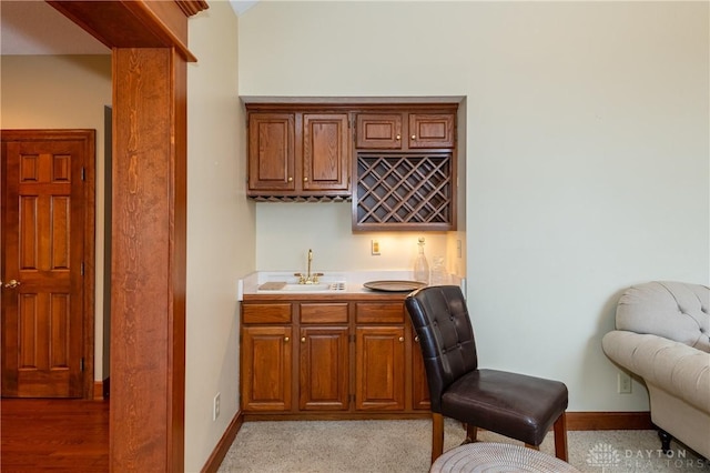 bar featuring sink and light carpet