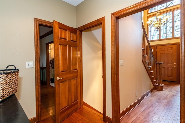 hall featuring light wood-type flooring and an inviting chandelier