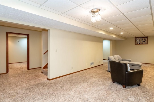 carpeted living room with a drop ceiling