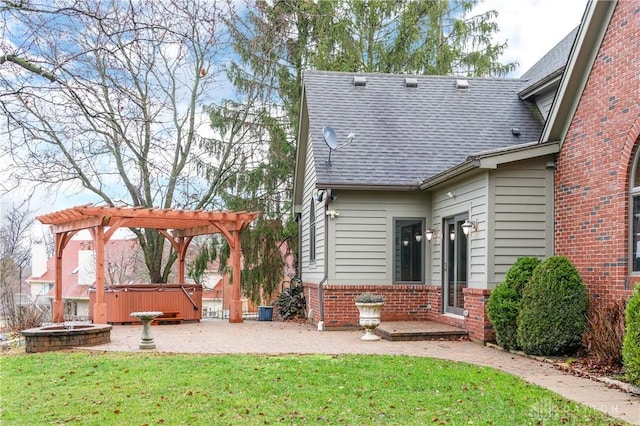 rear view of house with a pergola, a lawn, a patio, and a hot tub