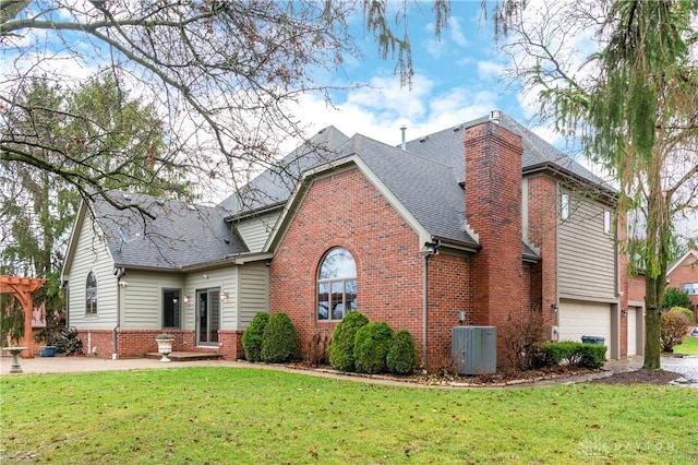 view of front property featuring central AC unit, a garage, and a front yard