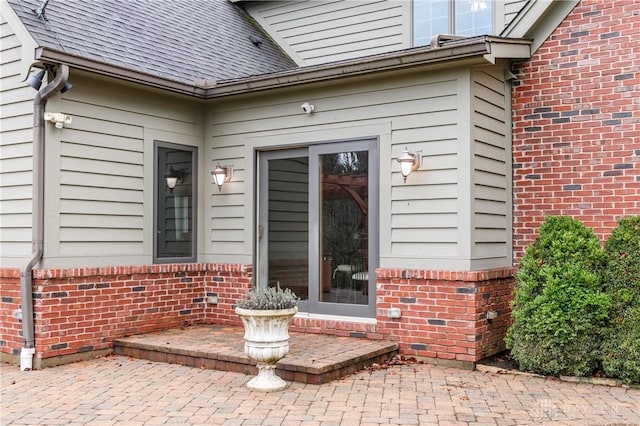 view of exterior entry with a patio