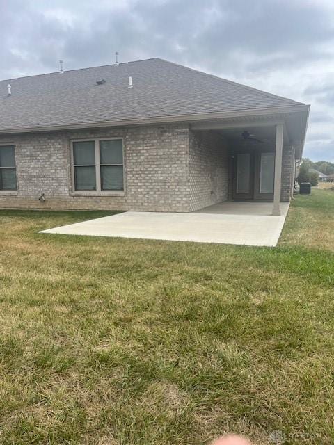 rear view of house featuring a yard and a patio