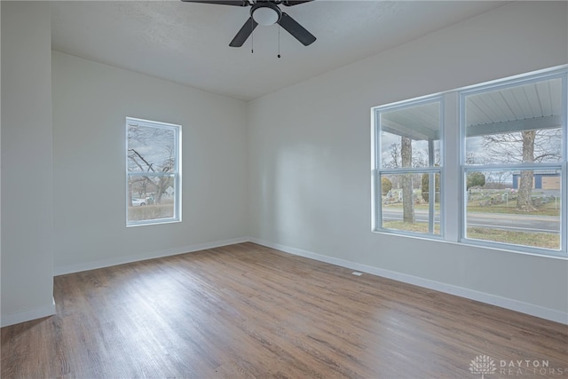 empty room featuring ceiling fan, light hardwood / wood-style floors, and a healthy amount of sunlight