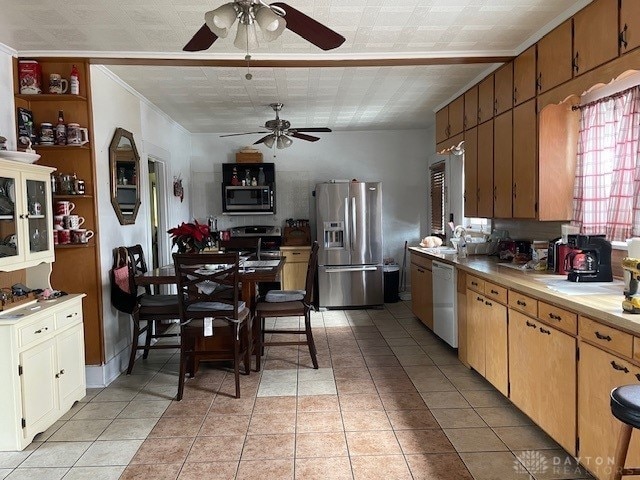 kitchen featuring light tile patterned floors, stainless steel appliances, and ornamental molding