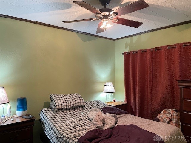 bedroom featuring ceiling fan and ornamental molding