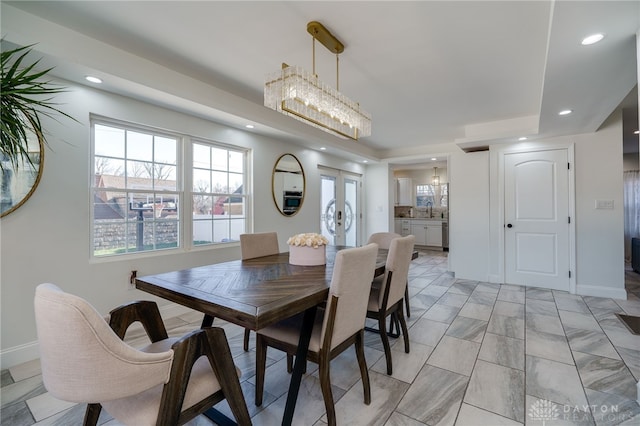 dining space featuring sink, a chandelier, and french doors