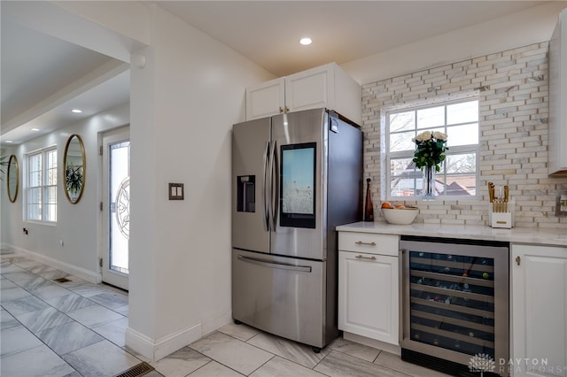 kitchen featuring stainless steel fridge with ice dispenser, white cabinetry, wine cooler, and plenty of natural light