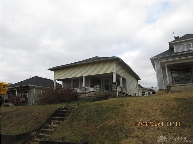 view of front of property featuring covered porch and a front lawn