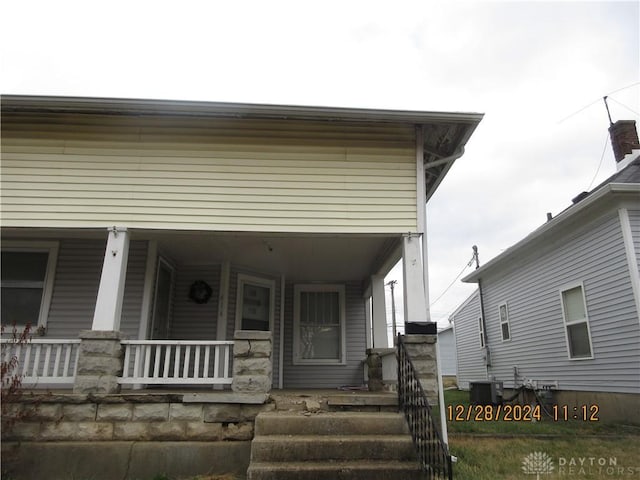 view of front of property with cooling unit and covered porch