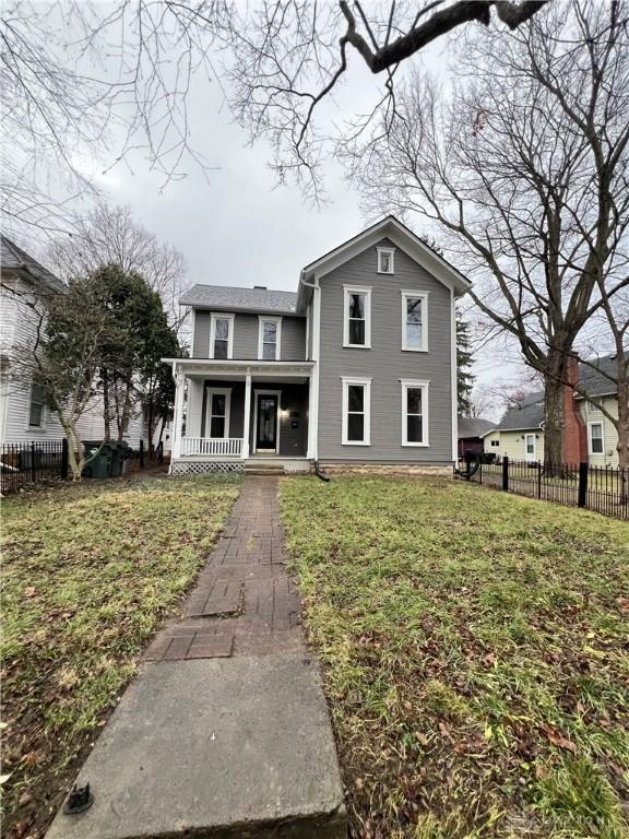 view of front of property featuring covered porch and a front lawn