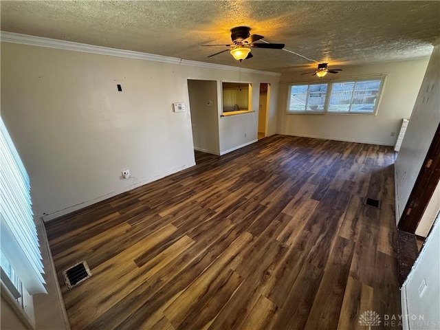 unfurnished living room with ceiling fan, ornamental molding, a textured ceiling, and dark wood-type flooring