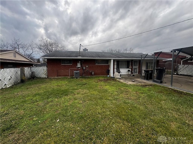 rear view of house featuring a yard, cooling unit, and a patio