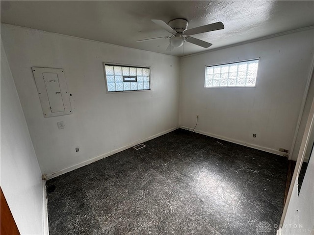 empty room featuring electric panel, ceiling fan, and a textured ceiling