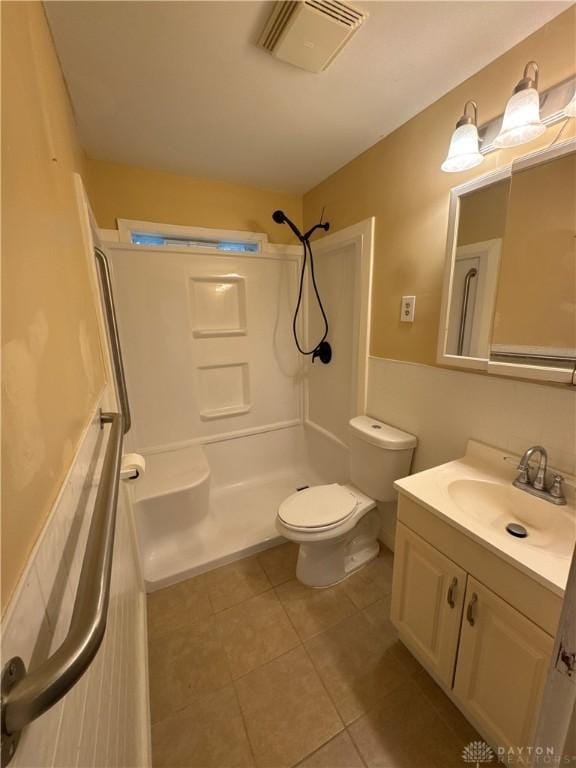 bathroom with a shower, vanity, toilet, and tile patterned flooring