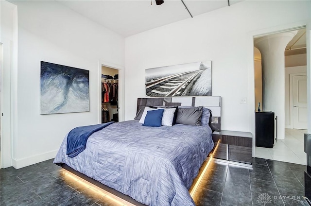 bedroom featuring dark tile patterned flooring, a spacious closet, and a closet