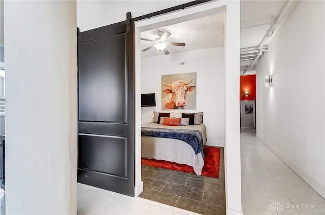 tiled bedroom with a barn door and ceiling fan