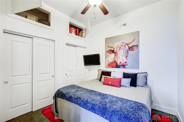 tiled bedroom featuring ceiling fan