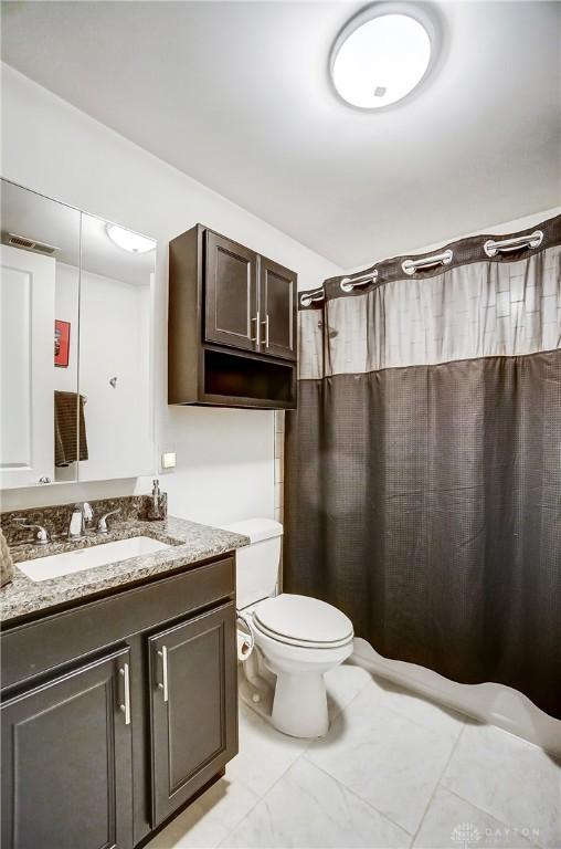 bathroom featuring a shower with curtain, vanity, and toilet