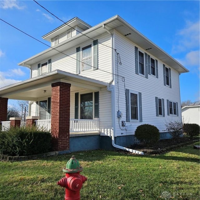 view of front facade with a front yard and covered porch