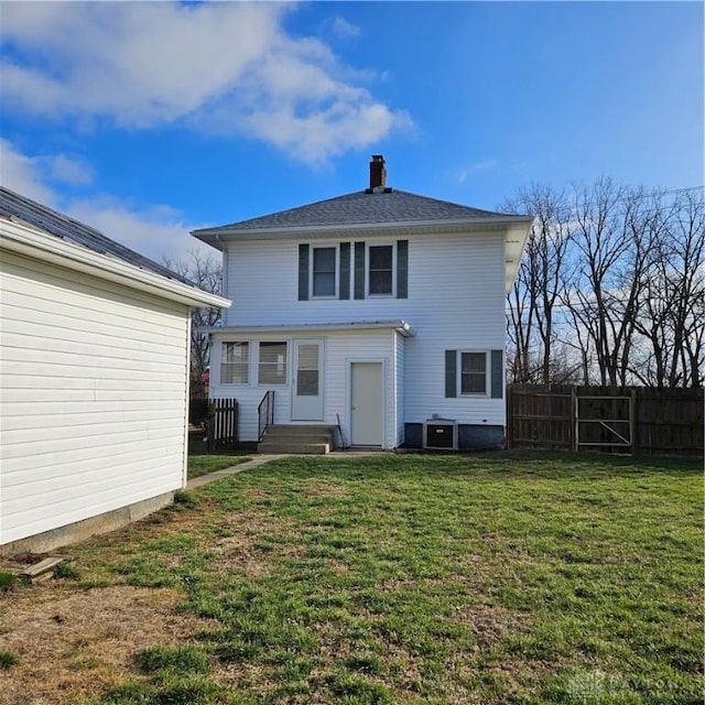 back of property with central air condition unit and a lawn