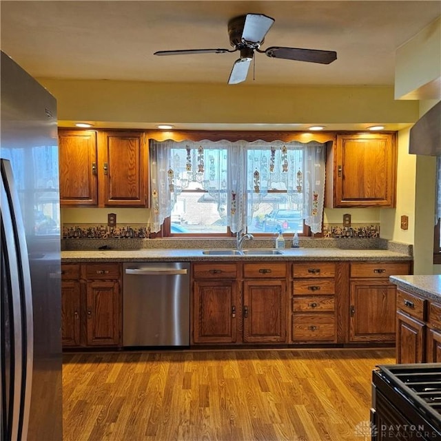 kitchen featuring ceiling fan, appliances with stainless steel finishes, sink, and light hardwood / wood-style floors