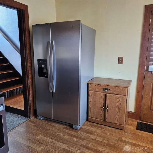 kitchen with hardwood / wood-style flooring and stainless steel fridge with ice dispenser