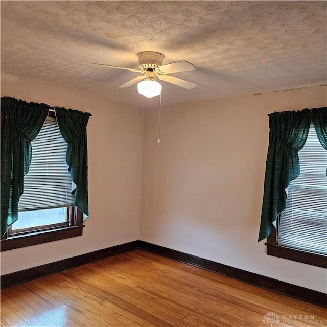 unfurnished room featuring ceiling fan, hardwood / wood-style flooring, and a textured ceiling