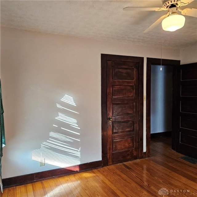 unfurnished room featuring hardwood / wood-style flooring, ceiling fan, and a textured ceiling