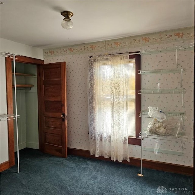 unfurnished bedroom with a closet and dark colored carpet