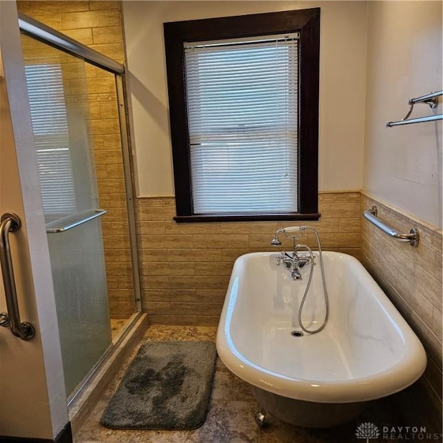 bathroom with tile walls and plus walk in shower