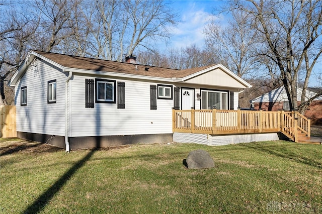 rear view of house with a lawn and a deck