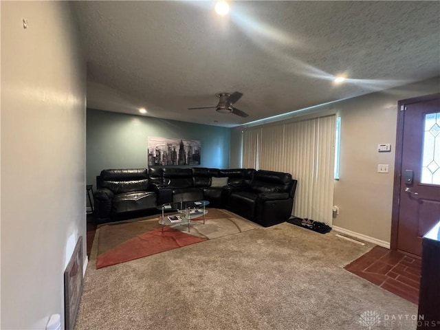 living room featuring carpet, ceiling fan, and a textured ceiling