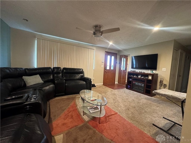 carpeted living room with ceiling fan and a textured ceiling