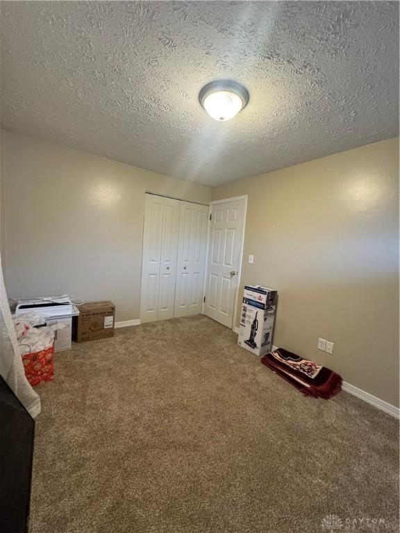 bedroom featuring a closet, carpet floors, and a textured ceiling