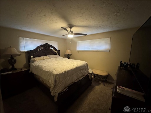 bedroom with ceiling fan, dark carpet, and a textured ceiling