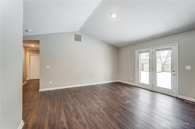 spare room with lofted ceiling and dark wood-type flooring