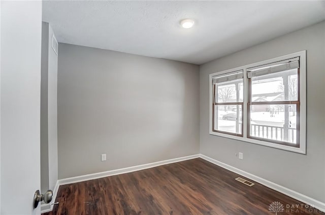 spare room with dark hardwood / wood-style flooring