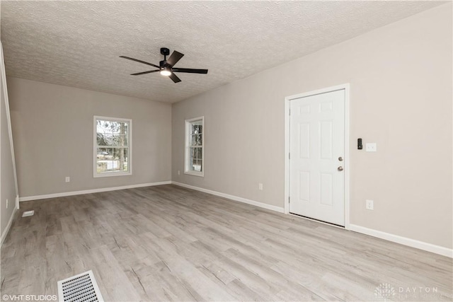 unfurnished room with ceiling fan, light hardwood / wood-style flooring, and a textured ceiling