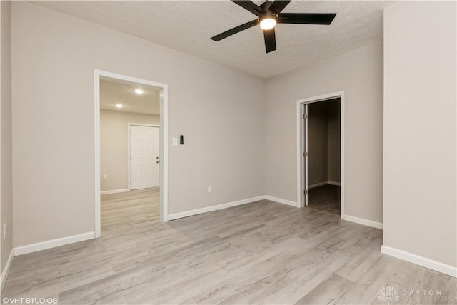 unfurnished room featuring ceiling fan, light hardwood / wood-style floors, and a textured ceiling