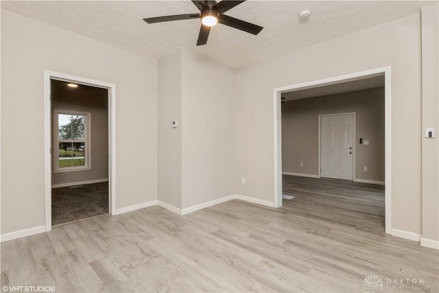 unfurnished room with ceiling fan, light hardwood / wood-style floors, and a textured ceiling