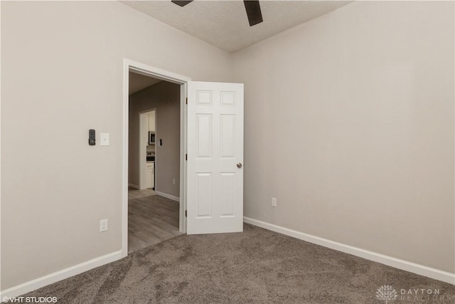 carpeted spare room featuring a textured ceiling and ceiling fan