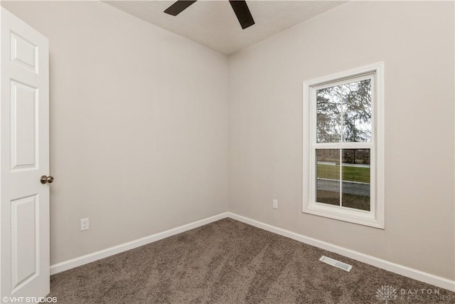 unfurnished room with ceiling fan and carpet